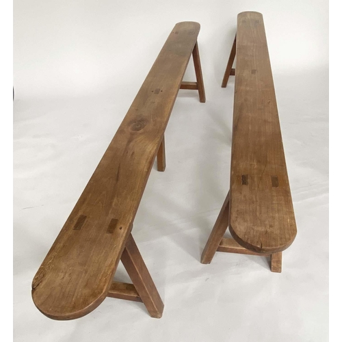 264 - BENCHES, a pair, 19th century French cherry wood rectangular with trestle supports, 231cm W. (2)