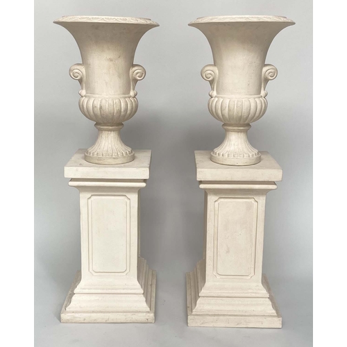 253 - URNS ON STANDS, a pair, campana form stone effect on plinths, 46cm W x 135cm H. (2)