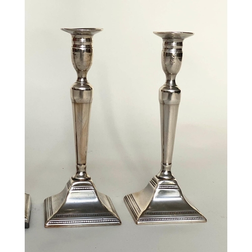 125 - CANDLESTICKS, a pair, early 20th century, Georgian style silvered with fluted columns and stepped pl... 