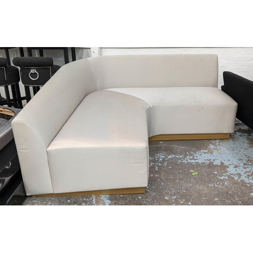 525 - CORNER SOFA, neutral upholstered, gilt plinth base, 84cm H x 190cm W x 190cm L x 90cm D.