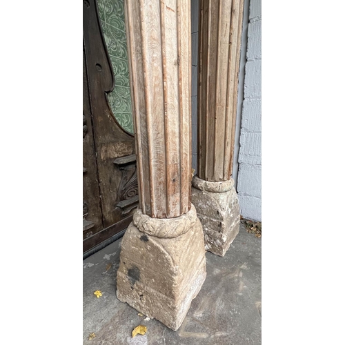 171 - COLUMNS, a pair, Indian carved hardwood with stone bases, approx 247cm H. (2)