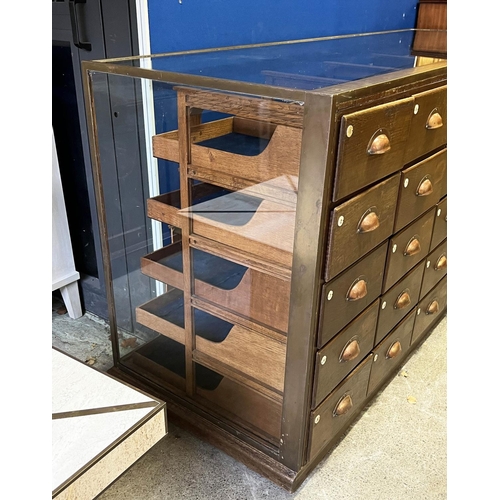 547 - HABERDASHERY COUNTER, oak and bronze framed with glass sides and back with an arrangement of 30 draw... 