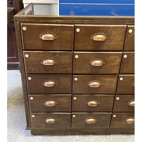 547 - HABERDASHERY COUNTER, oak and bronze framed with glass sides and back with an arrangement of 30 draw... 