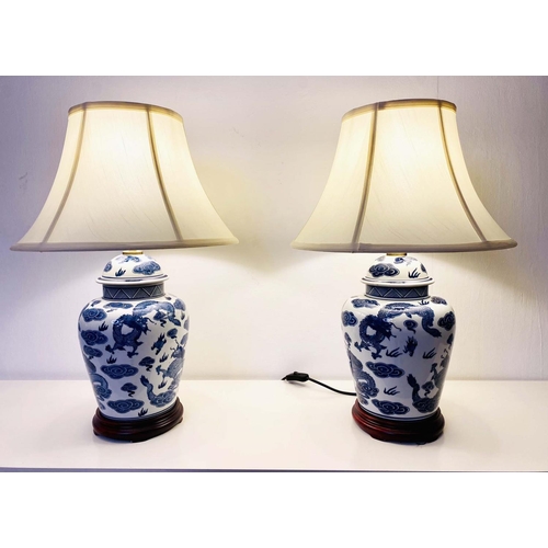 410 - TABLE LAMPS, a pair, Chinese export style blue and white ceramic with dragon design, with shades. (2... 