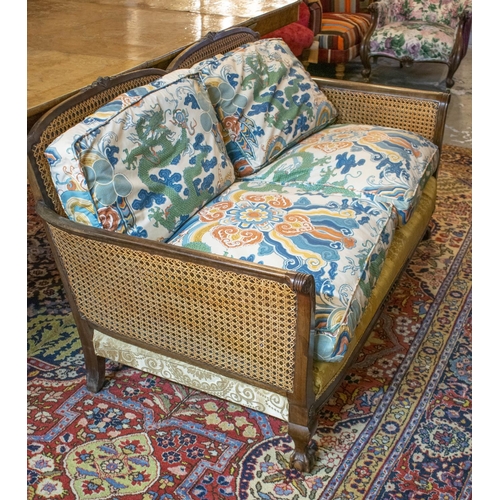 289 - BERGERE SOFA, 76cm H x 147cm W, early 20th century with double caned arms and loose cushions in drag... 