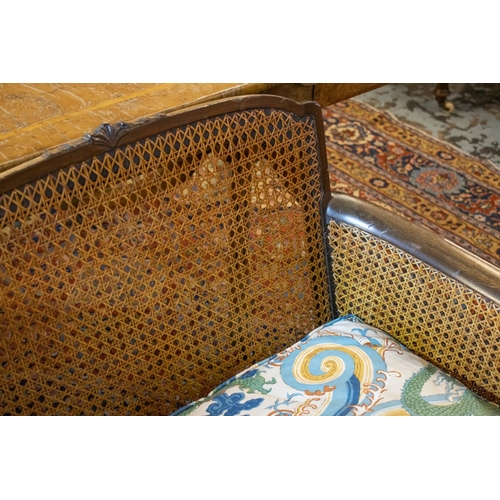 289 - BERGERE SOFA, 76cm H x 147cm W, early 20th century with double caned arms and loose cushions in drag... 