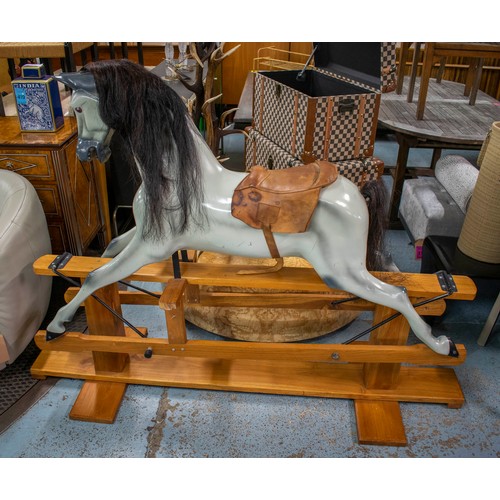 277 - ROCKING HORSE, 129cm H x 180cm L x 56cm W, painted fibreglass with leather saddle on wood stand.