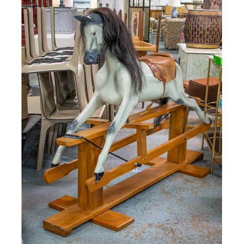 277 - ROCKING HORSE, 129cm H x 180cm L x 56cm W, painted fibreglass with leather saddle on wood stand.