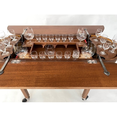 298 - COCKTAIL TROLLEY, 1950s mahogany oval opening foldout filled, rising interior with castors, 115cm W ... 