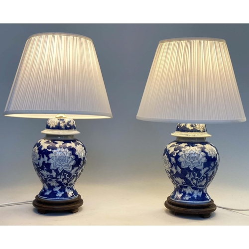 135 - TABLE LAMPS, a pair, Chinese blue and white ceramic of vase form with carved wooden bases and shades... 