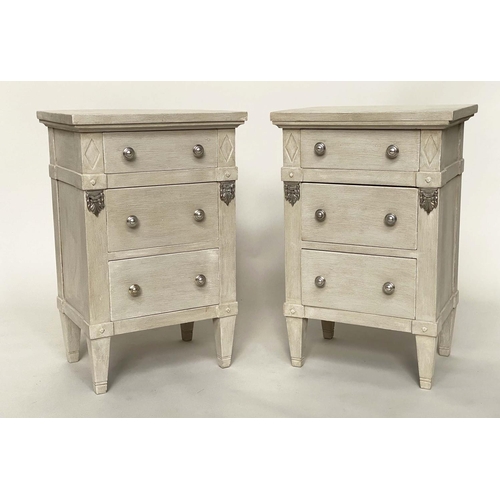 120 - BEDSIDE CHESTS, a pair, Gustavian style grey painted and silvered metal mounted each with three draw... 