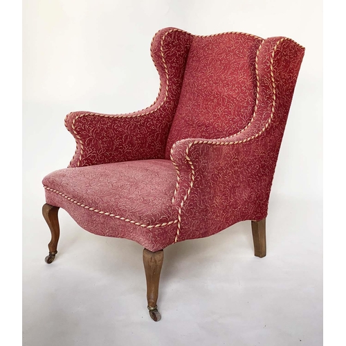 149 - WING ARMCHAIR, early 20th century deep seated of serpentine top and front with faded rose weave and ... 