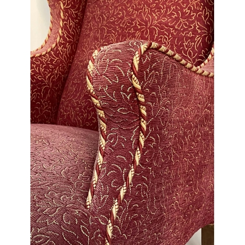 149 - WING ARMCHAIR, early 20th century deep seated of serpentine top and front with faded rose weave and ... 