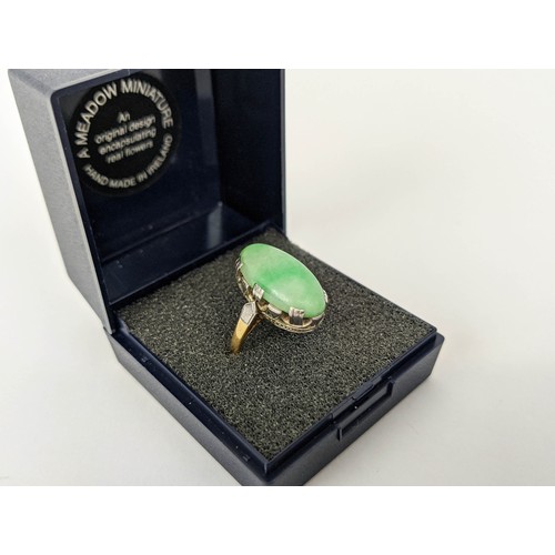 9 - AN 18CT GOLD AND JADE SET DRESS RING, the single jade cabouchon in a white metal pierced setting, ri... 