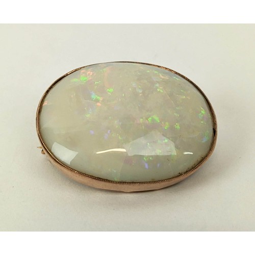 16 - A YELLOW METAL AND OPAL SET BROOCH, probably 9ct rose gold, spiders web design to back, the oval cab... 