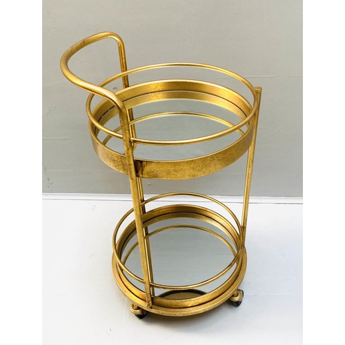 423 - COCKTAIL TROLLEY, 77cm high, 42cm diameter, 1960s French style, gilt metal frame with glass shelves