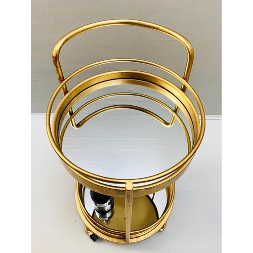 423 - COCKTAIL TROLLEY, 77cm high, 42cm diameter, 1960s French style, gilt metal frame with glass shelves