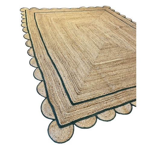 221 - SCALLOPED EDGE JUTE RUG, 307cm x 238cm.