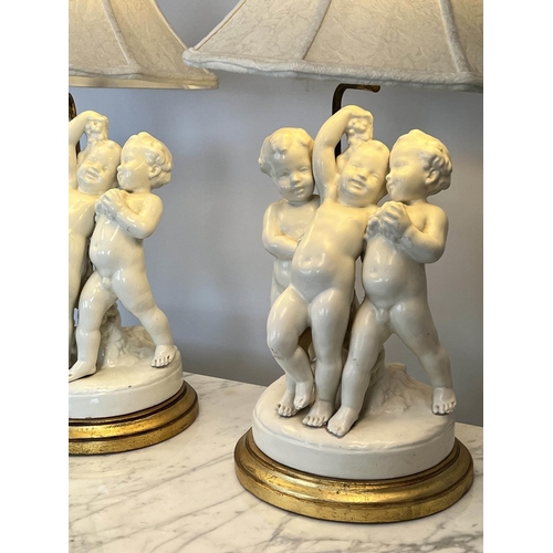 138 - TABLE LAMPS, a pair, blanc de chine porcelain putti on giltwood bases, with shades, 66cm H. (2)