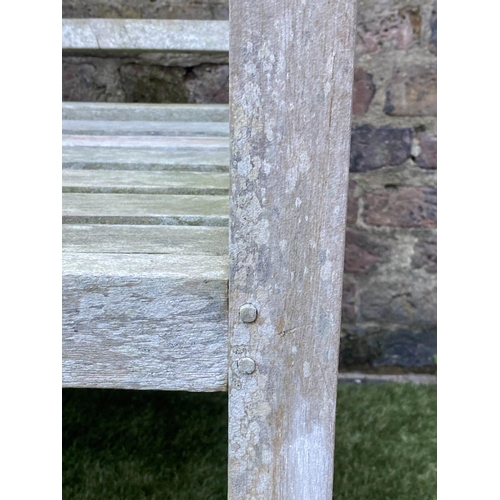 197 - LUTYENS STYLE GARDEN BENCH, weathered teak of slatted constructions after a design by Sir Edwin Luty... 