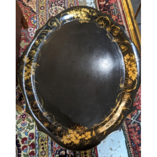 111 - VICTORIAN TRAY ON STAND, black papier mâché,  scalloped oval gilt vine leaf decoration, folding, on ... 