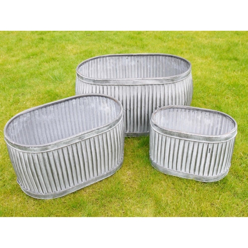 385 - TROUGH PLANTERS, a graduated set of three, largest measuring 35cm high, 64cm long, 40cm wide, galvan... 