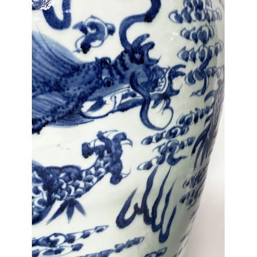 148 - DRAGON TEMPLE VASES, a pair, Chinese blue and white ceramic floor standing with lids, 105cm H. (2)