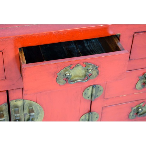 255 - CHINESE LACQUER CABINET, in rouge lacquer of eight drawers and a single central cabinet, 133cm x 60c... 