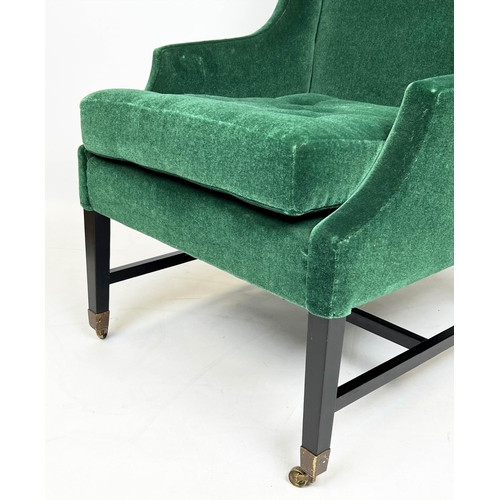 174 - WING ARMCHAIR, moss green mohair velvet upholstered with ebonised base and brass front castors, 105c... 