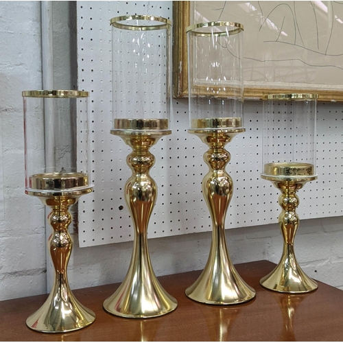 307 - STORM LANTERNS, two graduated pairs, gilt metal and glass, 48.5cm H at tallest. (4)