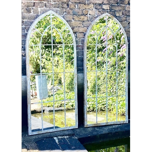 395 - ARCHITECTURAL GARDEN MIRRORS, a pair, 160cm high, 67cm wide, arched aged metal frames. (2)