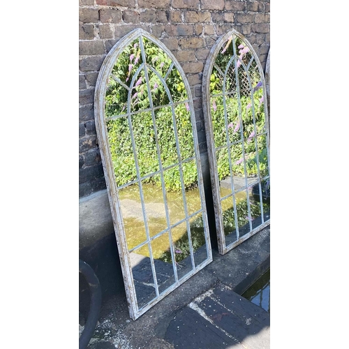 395 - ARCHITECTURAL GARDEN MIRRORS, a pair, 160cm high, 67cm wide, arched aged metal frames. (2)