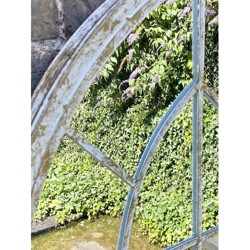 395 - ARCHITECTURAL GARDEN MIRRORS, a pair, 160cm high, 67cm wide, arched aged metal frames. (2)