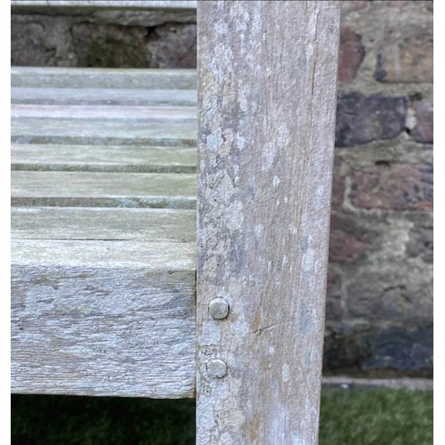 297 - LUTYENS STYLE GARDEN BENCH, weathered teak of slatted construction after a design by Sir Edwin Lutye... 