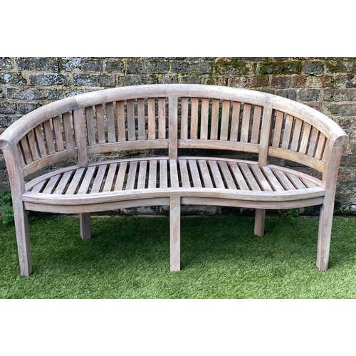 299 - BANANA GARDEN BENCH, weathered teak and slatted of arched form, 160cm W.