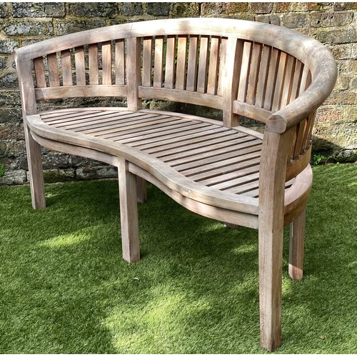 299 - BANANA GARDEN BENCH, weathered teak and slatted of arched form, 160cm W.