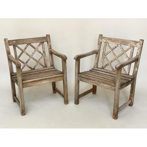 128 - GARDEN ARMCHAIRS BY ALEXANDER ROSE, a pair, weathered teak each slatted construction with lattice ba... 