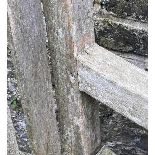 131 - GARDEN BENCH, weathered teak of large size and substantial slatted construction, 180cm W.