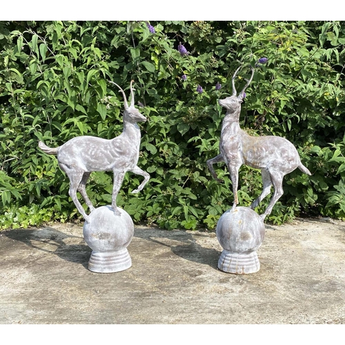 443 - SCULPTURAL STAGS, a pair, 100cm high, 60cm wide, cast metal, raised on globular bases. (2)