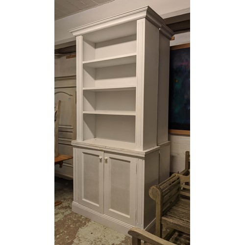 437 - BOOKCASE, 245cm H x 41cm x 107cm, painted finish with grilled doors.