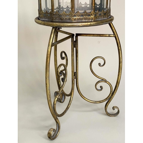 127 - STORM LANTERNS ON STAND, a pair, metal and glazed with handles and scroll supports, 106cm H. (2)