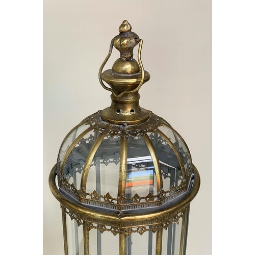 127 - STORM LANTERNS ON STAND, a pair, metal and glazed with handles and scroll supports, 106cm H. (2)