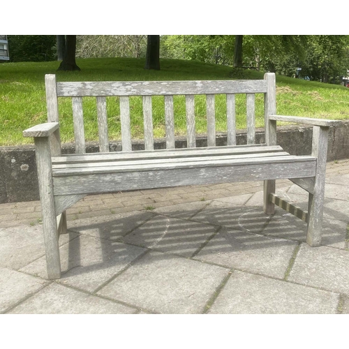 130 - GARDEN BENCH BY LISTER, silvery weathered teak of slatted construction with flat top arms by R A Lis... 