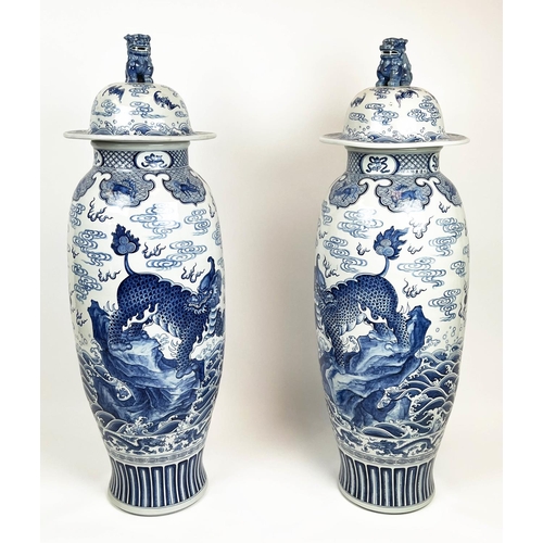 32 - LIDDED TEMPLE VASES, a pair, Chinese blue and white decorated with mythical lions, dragons bats and ... 