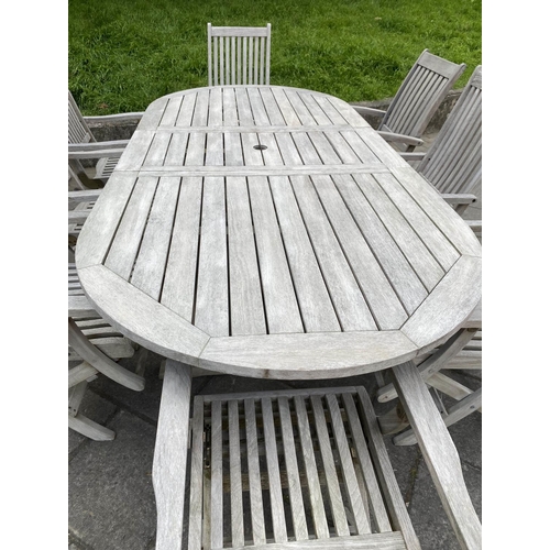 120 - GARDEN EXTENDING TABLE AND CHAIRS, silvery weathered teak, slatted construction rounded rectangular ... 