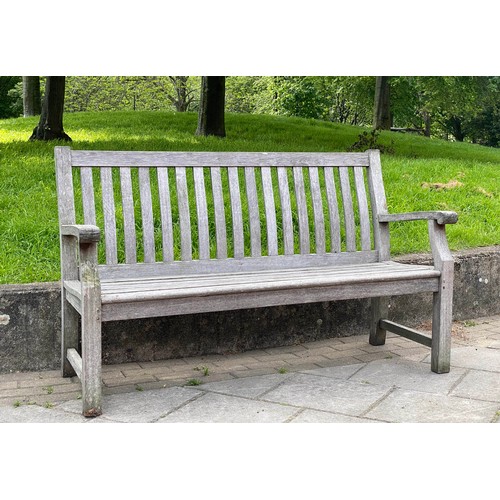 239 - GARDEN BENCH, weathered teak of slatted construction with shaped back and scroll arms, 152cm W.