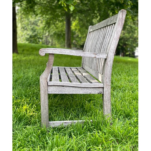 239 - GARDEN BENCH, weathered teak of slatted construction with shaped back and scroll arms, 152cm W.