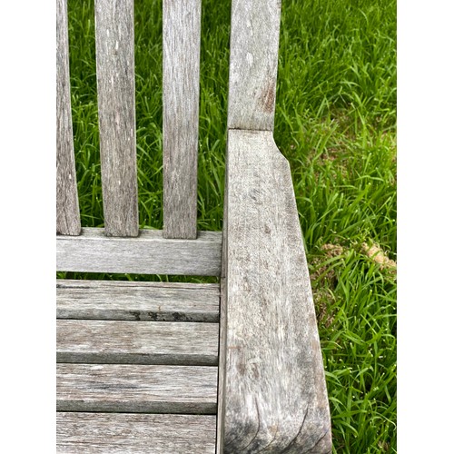 239 - GARDEN BENCH, weathered teak of slatted construction with shaped back and scroll arms, 152cm W.