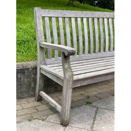 239 - GARDEN BENCH, weathered teak of slatted construction with shaped back and scroll arms, 152cm W.