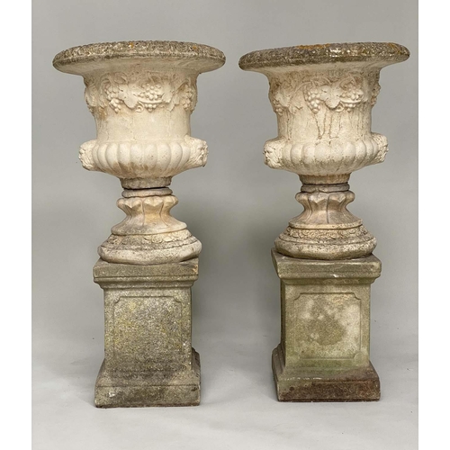 174 - GARDEN URNS, a pair, well weathered reconstituted stone each of campana form, with vine decoration o... 